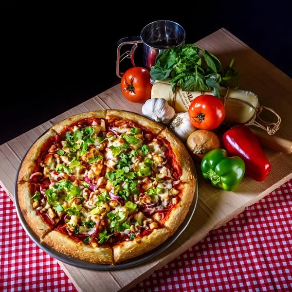 Free Wheeler Pizza with chicken, red onion, and cilantro, surrounded by fresh ingredients.