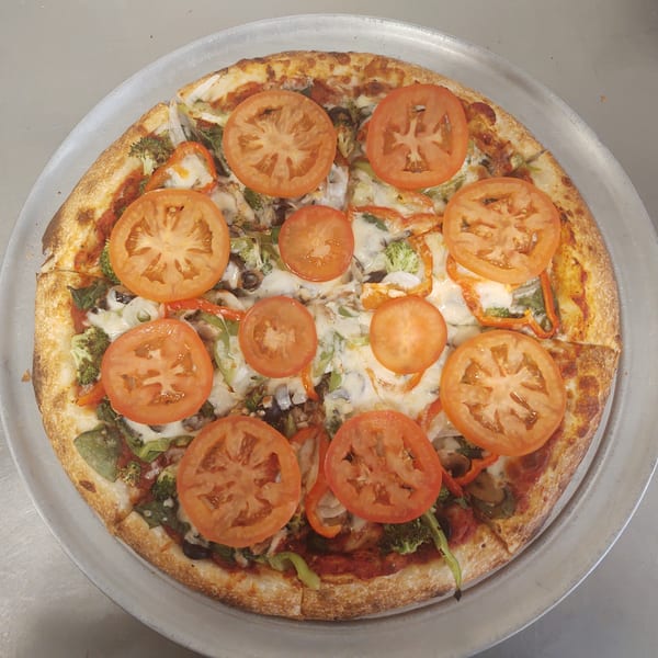 Free Wheeler Pizza's vegetarian pizza, topped with fresh tomatoes, broccoli, and bell peppers.